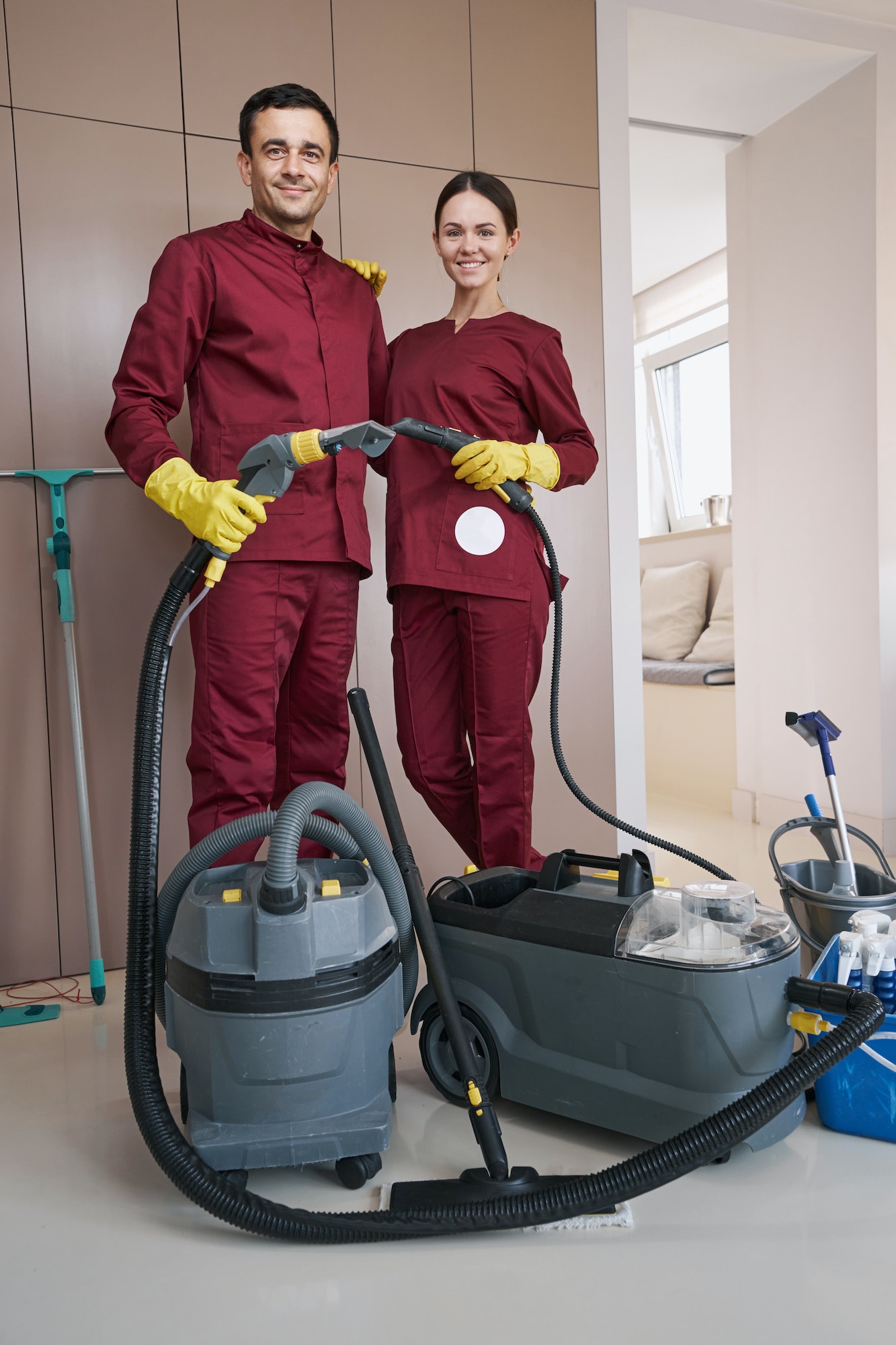 Two workers with cleaning equipment posing for camera